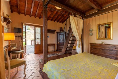 een slaapkamer met een bed, een bureau en een ladder bij Borgo Dolci Colline Resort Limonaia in Castiglion Fiorentino