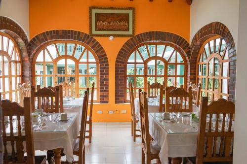 a dining room with tables and chairs and windows at Hotel Beth Sarim By Legendary in Villa de Leyva