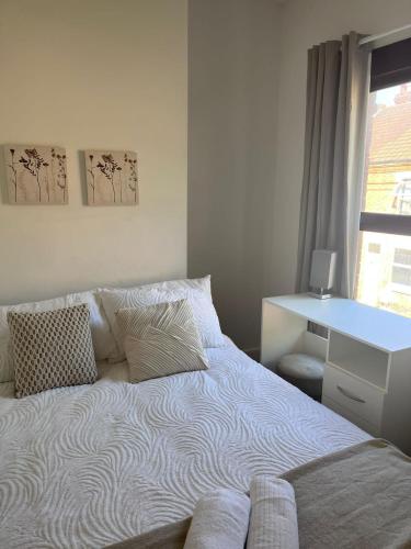 a bedroom with a bed with a desk and a window at Inviting Town House in Coventry