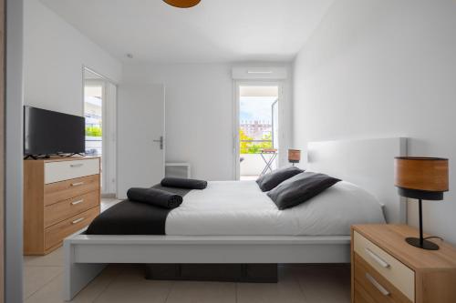 - une chambre avec un lit, une télévision et un couvre-lit dans l'établissement T2 Entre la plage et le Vélodrome - Clim/Parking, à Marseille