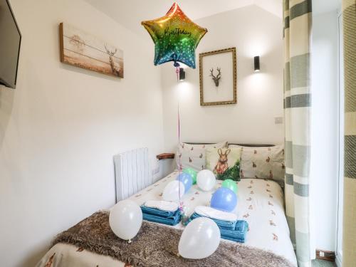 een kleine slaapkamer met een bed met ballonnen erop bij The Old Smokehouse in Rugeley