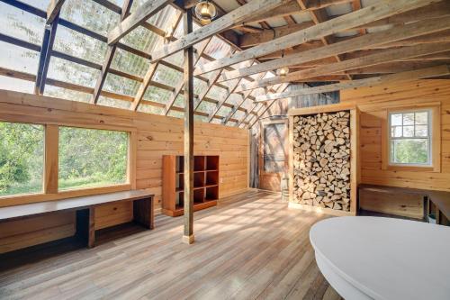kabina z bali z dużym pokojem z drewnianymi podłogami i oknami w obiekcie Luxe 14-Acre Vermont Countryside Vacation Rental! w mieście East Orange