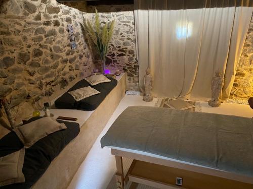 a room with two beds and a stone wall at Chambre d'hotes Bessiard in Laparrouquial