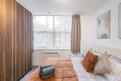 a bedroom with a bed and a large window at Modern flat in central golders green in London