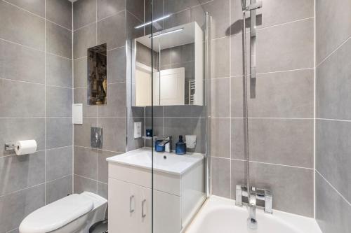 a bathroom with a toilet and a sink and a mirror at Modern flat in central golders green in London