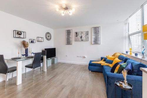 a living room with a blue couch and a table at Modern flat in central golders green in London
