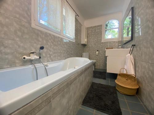 une grande salle de bain avec une baignoire et un lavabo dans l'établissement Maison en pleine nature -Domaine des mille pierres, à Laudun-l'Ardoise