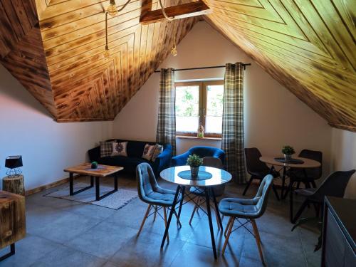 een woonkamer met houten plafonds en tafels en stoelen bij Pokoje Gościnne i Apartament Górski Widok in Czarna Góra