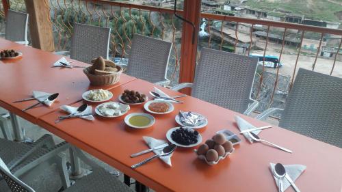 une table rouge avec des assiettes de nourriture dans l'établissement Gite Rahhaoui Simo, à Kasba des Aït Moussa