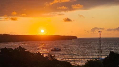 a boat in the water with the sunset in the background at Casa Ocean Pier in Puerto Ayora