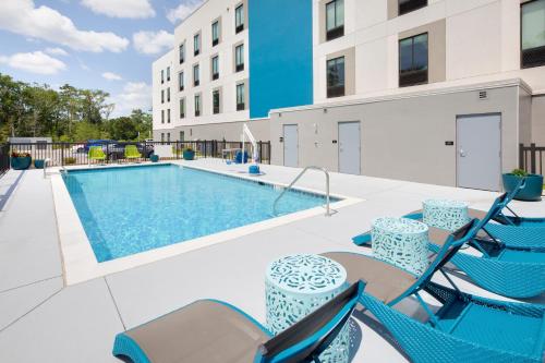 - une piscine avec des chaises et une table dans l'établissement Hampton Inn & Suites D'Iberville Biloxi, à Biloxi
