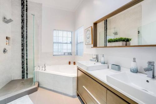 a bathroom with two sinks and a tub and a mirror at Prime location! House w/pool 7 mins to Universal, 10 mins to Hollywood in Los Angeles
