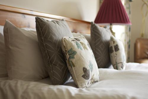 a group of pillows on a bed in a bedroom at Exmoor White Horse Inn in Exford