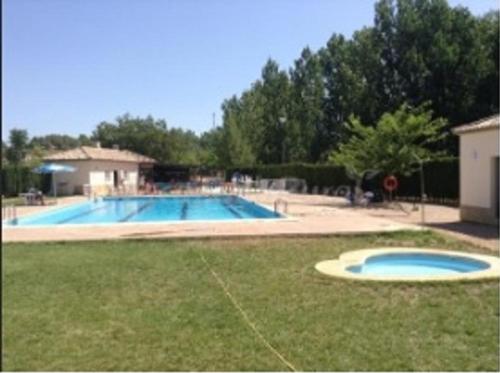 a large swimming pool in a yard next to a field at Casa Rural Casa Pepita in Jaraguas