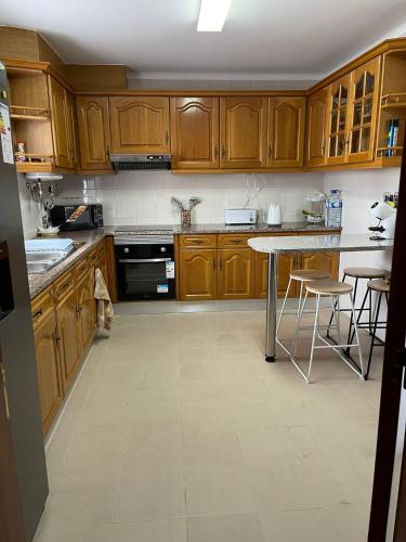 a kitchen with wooden cabinets and a table at O Nosso Recanto in Machico