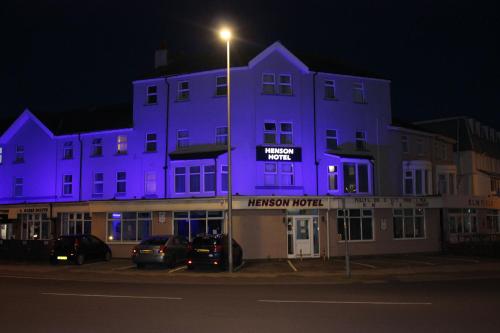 a purple building with cars parked in front of it at Henson Hotel Pleasure Beach in Blackpool