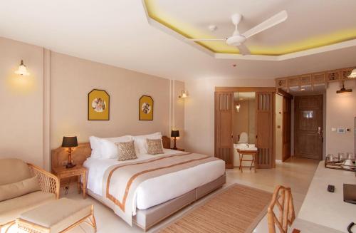 a bedroom with a large bed and a couch at Devasom Khao Lak Beach Resort & Villas in Khao Lak