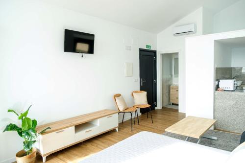 a bedroom with a bed and a tv on a wall at OS BALCÓNS Ría de Arousa in Boiro