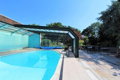 a swimming pool with a pergola next to a patio at Carnethic Penthouse in Fowey