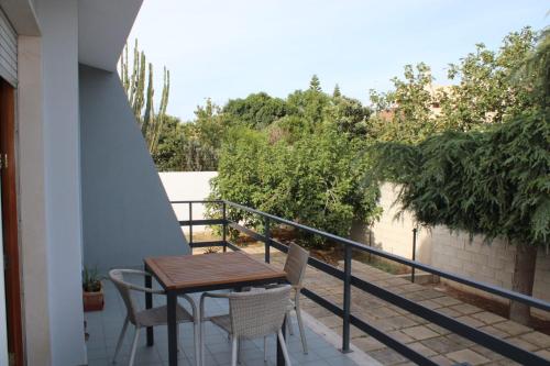 a balcony with a wooden table and chairs on it at Residenza Botticelli in Lecce