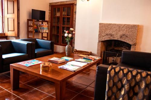 a living room with a table and a fireplace at Casa Sobreira da Silva - Alojamento Local in Almeida