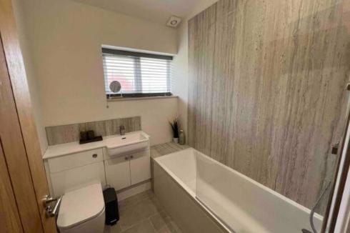 y baño con bañera, lavabo y aseo. en Silver Stag Properties, 3 BR Sandstone Lodge, 