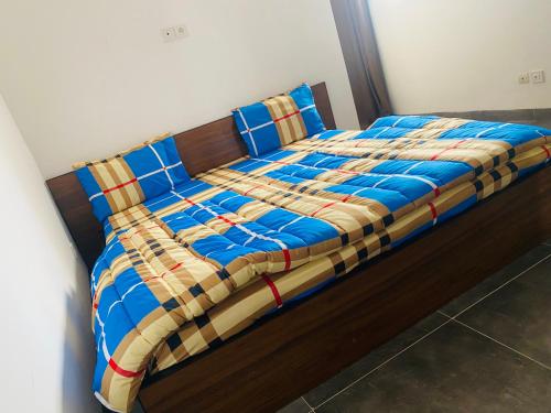 a bed with a blue comforter and blue pillows at RÉSIDENCE LA CENTENAIRE in Dakar