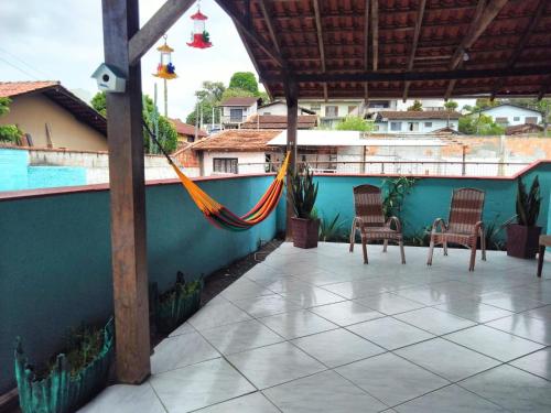 um pátio com cadeiras e uma rede de descanso junto a uma piscina em Casa Verde em Joinville