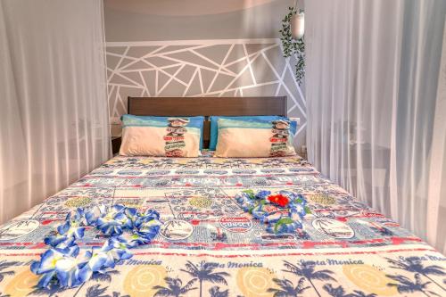 Aloha Home في لوس أبريغوس: غرفة نوم مع سرير ولحاف ملون