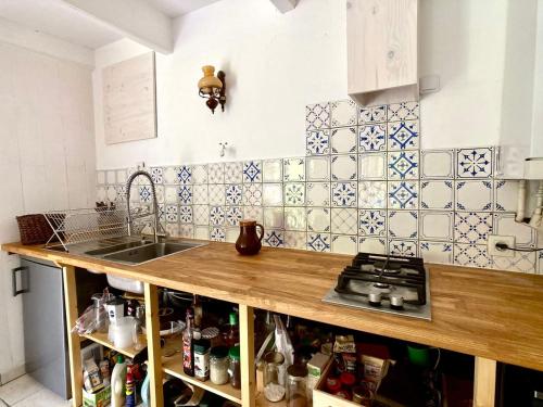 uma cozinha com um lavatório e uma bancada em LA MAISON BLEUE,authenticité, nature, simplicité, 2-5 personnes, Moëlan sur Mer em Moëlan-sur-Mer