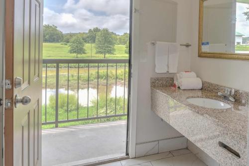 a bathroom with a sink and a balcony with a view at Econo Lodge on the River Sevierville-Pigeon Forge in Sevierville