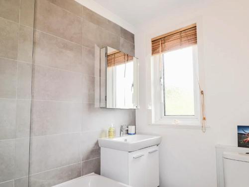 a bathroom with a sink and a toilet and a window at Little Loch View in Durnamuck