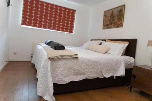 4 bedroom home - free parking by Ideel Apartments in Milton Keynes في Wolverton: غرفة نوم عليها سرير وبطانية