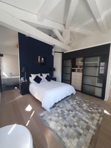 a large bedroom with a white bed and a bathroom at Lou Pantai, Bed and Breakfast, Delux Bedroom in Aix-en-Provence