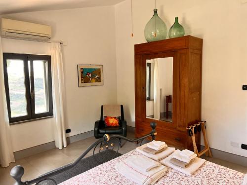 - une chambre avec un lit, un miroir et une chaise dans l'établissement La Fontanella Country House, à Celle sul Rigo