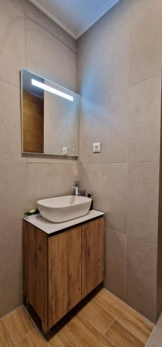 La salle de bains est pourvue d'un lavabo et d'un miroir. dans l'établissement Apartman N&E, à Bjelašnica