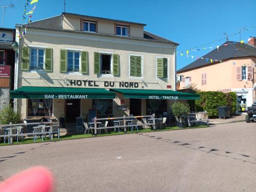 a building with tables and chairs in front of it at hotel du Nord in Brassy