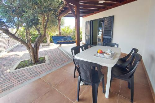 a white table and chairs on a patio at Oásis by BCA Villas in Porto Santo