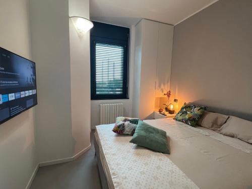 a bedroom with a large bed with a flat screen tv at Location in zona strategica- White House in Vimercate