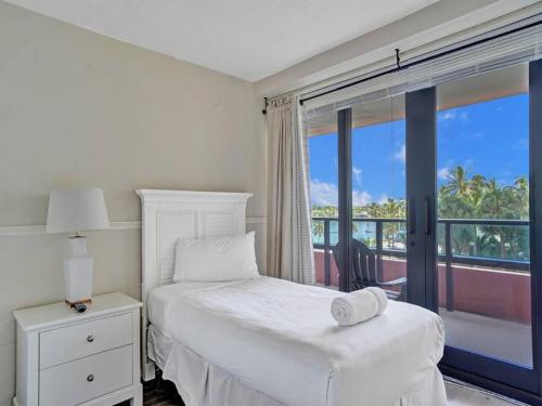a white bedroom with a bed and a balcony at Beachfront Ocean View Condo Beach Service 520 in Miami Beach