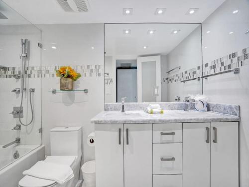 a white bathroom with a sink and a toilet at Beachfront Condo w Beach Service 1207 in Miami Beach