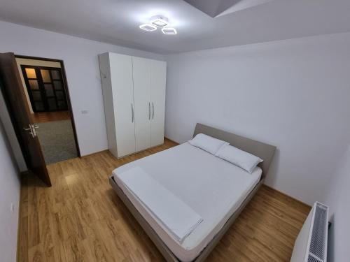a bedroom with a white bed and a closet at Casa Sava in Letea Veche