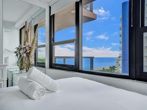 a bedroom with a bed and a large window at Beachfront Condo w Beach Service 1207 in Miami Beach