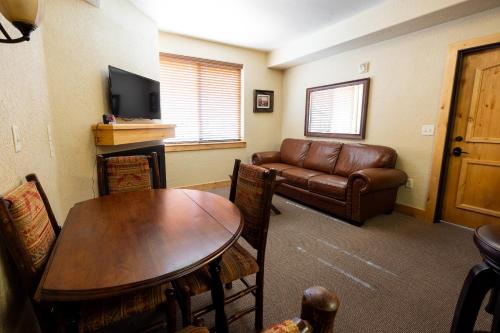 sala de estar con mesa y sofá de cuero en Silverado Lodge - 1 Bedroom Suite with King Bed & Pool View apartment hotel en Park City