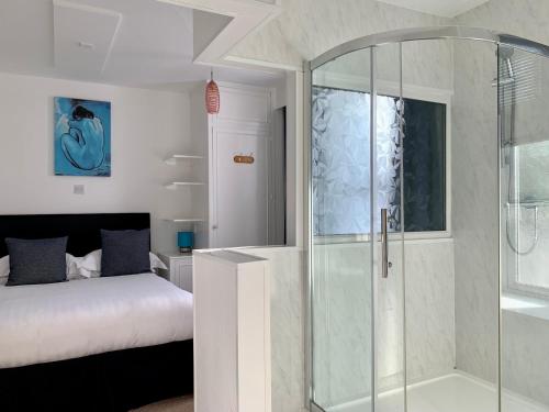 1 dormitorio con ducha de cristal y 1 cama en Sarum Apart-Hotel, en Saint Helier Jersey