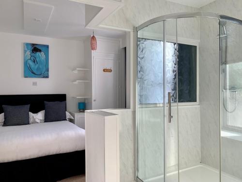 a bedroom with a glass shower and a bed at Sarum Apart-Hotel in Saint Helier Jersey
