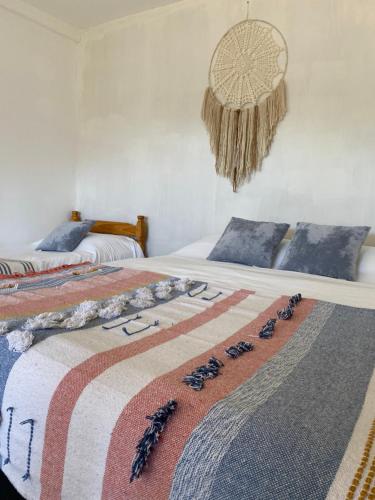 1 dormitorio con 2 camas con una manta con plumas en Dpto Samsara en El Chaltén