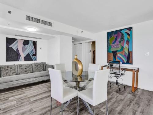 a dining room with a glass table and white chairs at Full ocean view Huge private terrace 1002 in Miami Beach