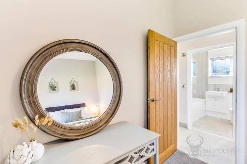 a large round mirror on a white wall in a bathroom at Silver Stag Properties, 2 BR Limestone Lodge 