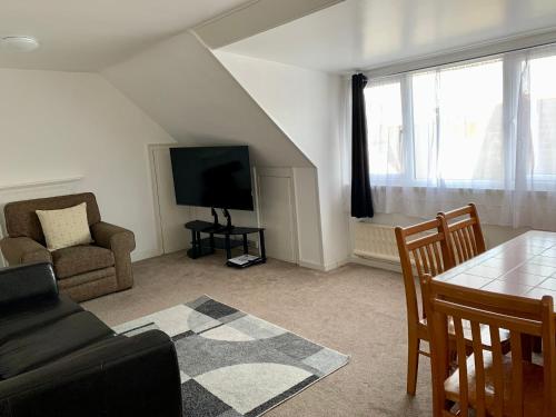 a living room with a couch and a tv and a table at Sarum Apart-Hotel in Saint Helier Jersey